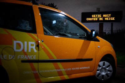 Une voiture de la DIR devant un panneau à message variable avec le message 