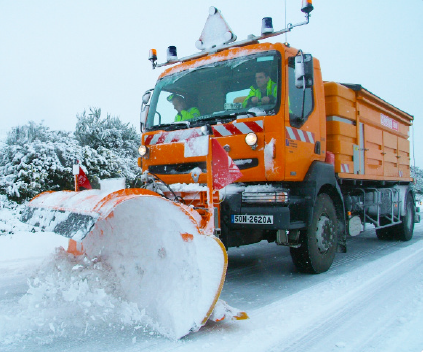 Une déneigeuse en action sur une route enneigée